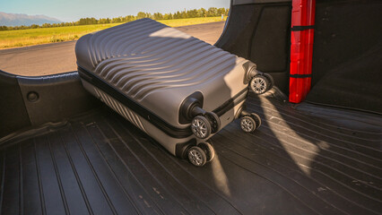 Suitcase placed inside car trunk, symbolizing upcoming travel and adventure
