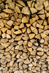 Stack of neatly chopped firewood in a wooden shed.