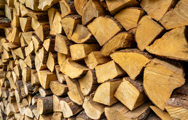 Stack of neatly chopped firewood in a wooden shed.