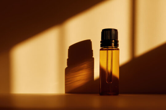 Amber glass bottle aromatherapy oil soft light warm shadow minimalist style relaxation wellness spa natural essence tranquil mood