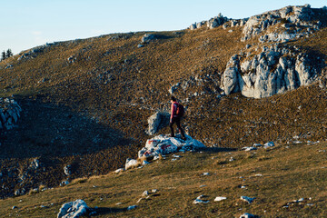 A female mountaineer, equipped with professional gear, enjoys the thrill of her climb as she...