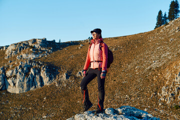 A female mountaineer, equipped with professional gear, enjoys the thrill of her climb as she...
