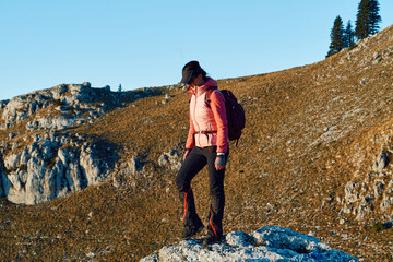 A female mountaineer, equipped with professional gear, enjoys the thrill of her climb as she...