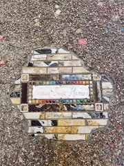 Artistic Tile Repairs in Urban Pavement Featuring message "Call your mother"
