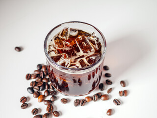 Iced black coffee, iced Americano coffee in glass and roasted coffee beans on white background.