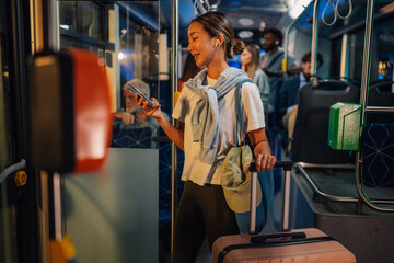 Young woman using smartphone while riding public transport bus