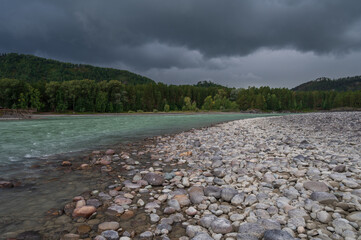 Fast mountain river Katun in Altay, Siberia, Russia. Cloudy skies before the rain