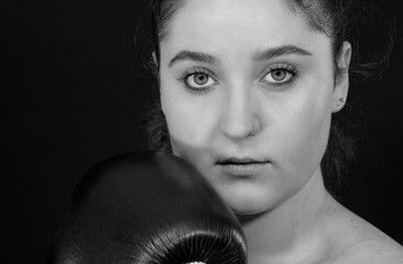 Junge Frau als Boxerin ist bereit und schaut konzentriert in die Kamera