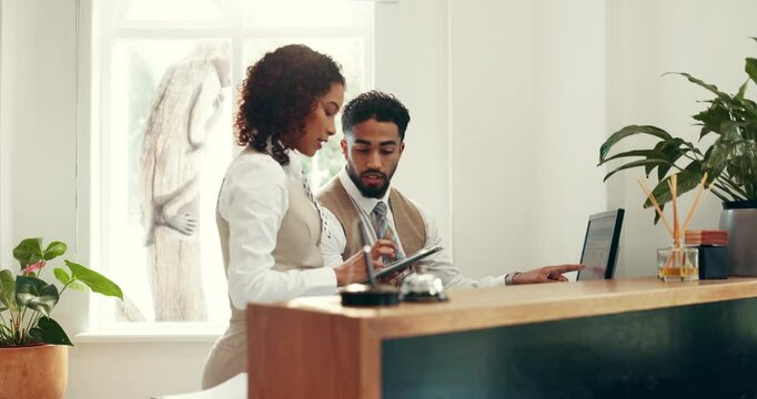 Hotel, computer or teamwork with tablet at front desk to compare booking info, availability or dates. Concierge service, people or screen with discussion for reservation management or upgrade request