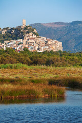 Historic hilltop town of Posada in Sardinia overlooking wetland landscape