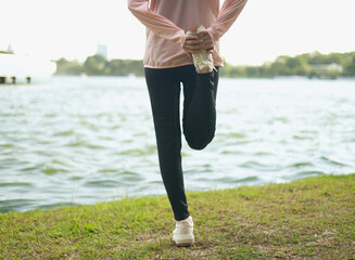 A woman getting ready to run and stretching, exercising before running.