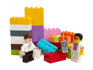 Naklejka premium Two Lego minifigures on the background of Lego bricks on a white background