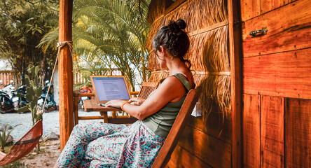 Close up young caucasian hipster woman sit use computer read news media articles, write travel blog...