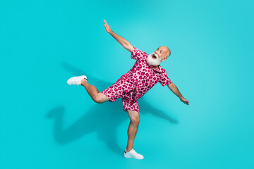 Full size photo of funny aged man balancing dancing wear leopard print outfit isolated on teal color background