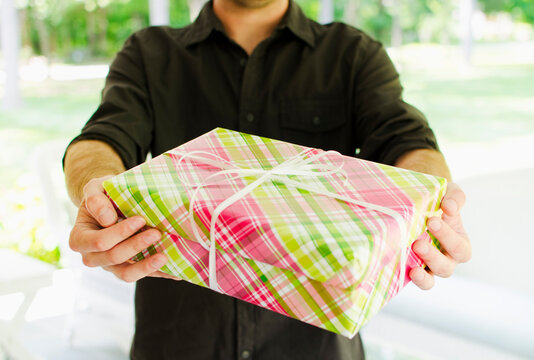 Mid section of man giving gift outdoors