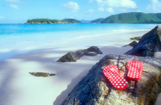 Red flip flop sandals on tropical beach