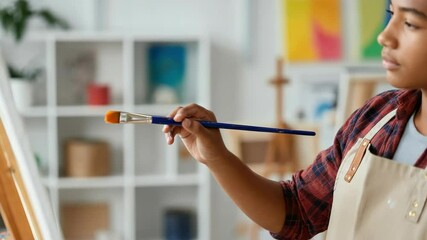 Young boy painting on canvas in art studio