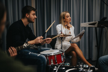 Musicians rehearsing with teacher in a studio while preparing for performance