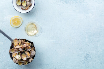 Vongole clams in a sauce pan, overhead flat lay shot with lemon and thyme. Seafood dish, with copy...