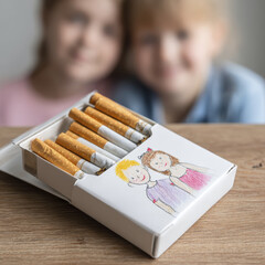 Colorful Cigarette Box Decorated with Artistic Illustrations Placed on Wooden Table with Children in Soft Focus Background