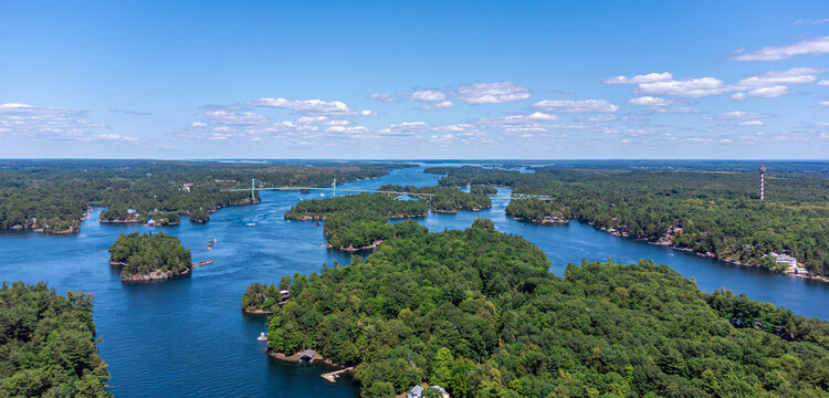 Aerial view of the Saint Lawrence River, Thousand Islands Bridge and 1000 Islands Tower, capturing lush green islands, blue water, and the Canada–US international border on summer day (July 2021)
