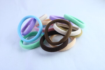 A pile of colorful fabric hair ties on a white background. Soft elastic bands used as hair...