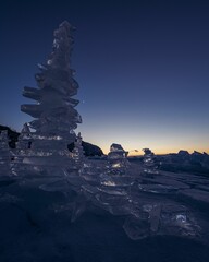 Ice formations on a frozen lake at sunset.