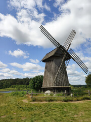 An old wooden windmill on a summer day. Mikhailovskoye Estate. Pushkin Hills, Russia. Landmark, vertical photo.