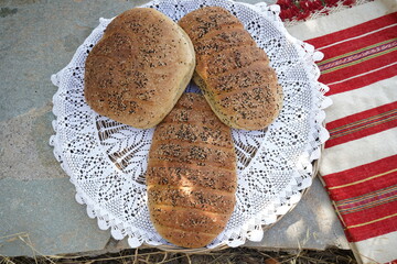 Top down view of Eftazymo bread in a woven basket on a knitted cloth under sunlight. Traditional...