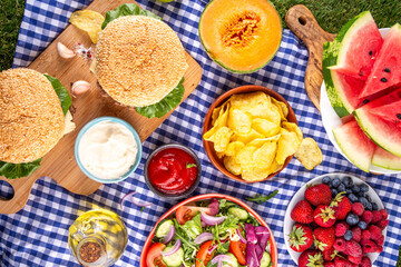 Summer picnic or BBQ brunch or lunch background, tasty barbecue table with hamburgers, salads,...