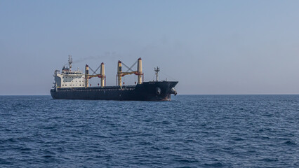 A large marine vessel transports cargo on the high seas. Navigation of large ships. A large cargo...