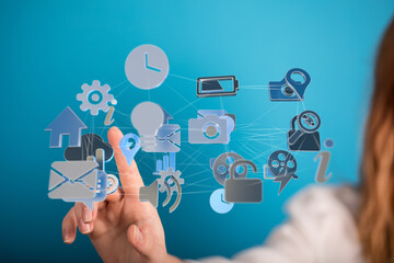 Hand interacting with a network of digital icons representing technology and connectivity.