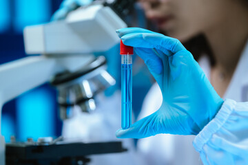 A female scientist conducts research in a modern laboratory, wearing protective gear, analyzing...