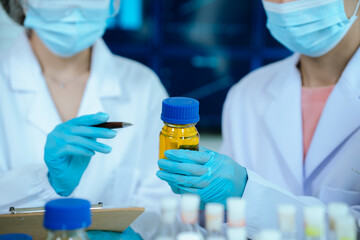 A female scientist in protective gear works in a sterile laboratory, conducting research and...