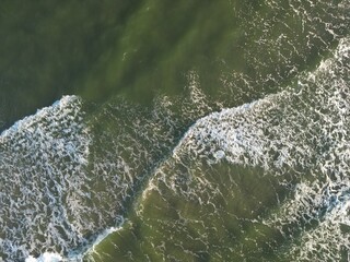 Aerial ocean photography capturing wave patterns and foam formations creating natural abstract art...