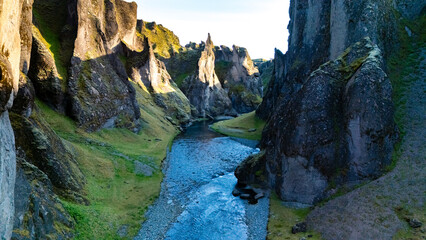 Experience the breathtaking beauty of Icelands rugged canyon, where towering cliffs rise...