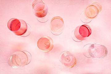 Rose wine variety, overhead flat lay shot, different hues and tints, on a pink background, many wine glasses, pastel banner