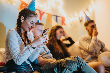 A group of family members enjoying a birthday celebration with party hats, decorations, and...