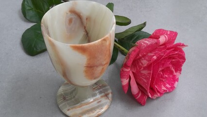 A composition consisting of a rose and a stone goblet,
carved from translucent onyx stone. It has smooth natural patterns in warm beige and brown tones, which gives it a noble and natural look.
