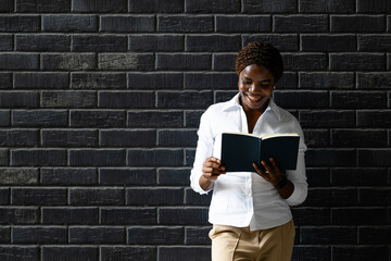 Smart African woman reading a book.