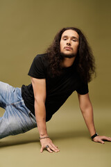 Handsome young man with bearded charm striking a confident pose in minimalist setting