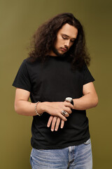 Handsome young man checks his watch, stylishly dressed in a casual setting