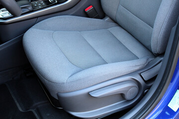 Close-up of light grey power seat. Fabric Ergonomic Premium driver Car Seat. Premium car light grey...