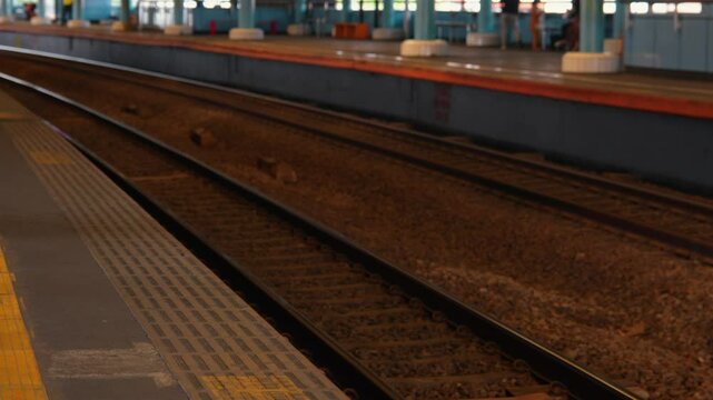 Empty Train Station Platform with Railway Tracks