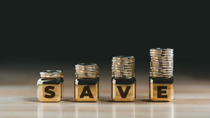 Stacked gold coins on gold cubes spelling SAVE representing financial growth investment planning...