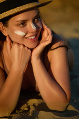 Beautiful Woman Face. Portrait Beauty Skin Care Concept. Beautiful Woman Applying on Face Suntan...