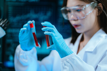 A scientist in a modern laboratory analyzes a blood sample using advanced biotechnology and equipment, conducting medical research for diagnostics, innovation, discovery, and healthcare development.