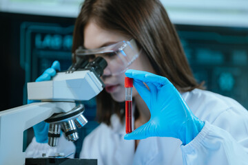 A scientist in a modern laboratory analyzes a blood sample using advanced biotechnology and equipment, conducting medical research for diagnostics, innovation, discovery, and healthcare development.