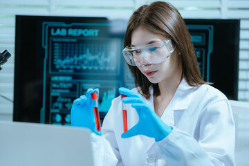 A scientist in a laboratory conducts a medical experiment with a red liquid in a test tube,...