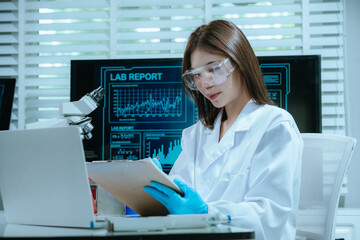 A scientist in a laboratory conducts a medical experiment with a red liquid in a test tube,...